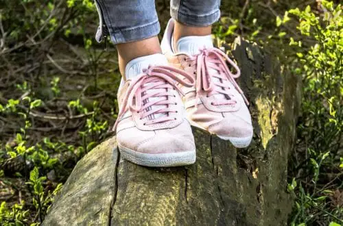 pink shoes balancing on a wooden log