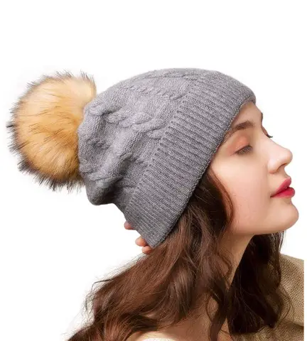 woman in a hat with a faux fur pom pom