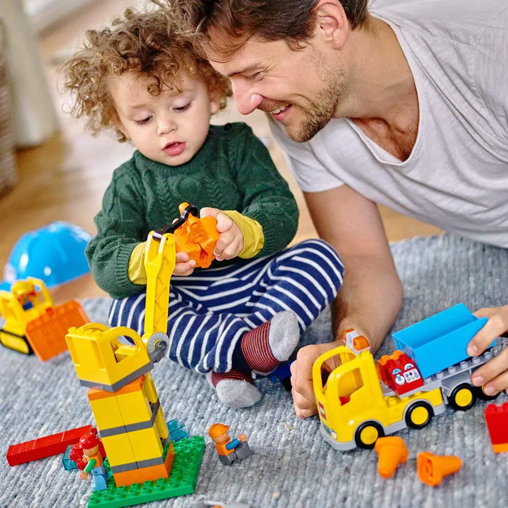 A dad playing lego duplos with his father 