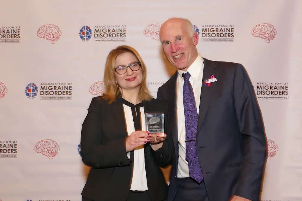 woman accepting an award from man for advocating for cannabis for migraine