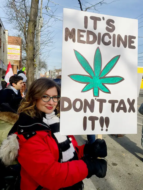 woman holding a sign advocating for cannabis for migraine