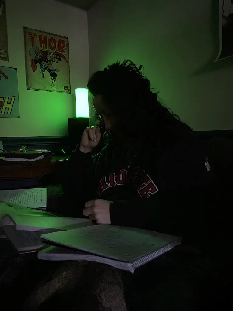 woman working in light of green allay lamp with migraine light sensitivity