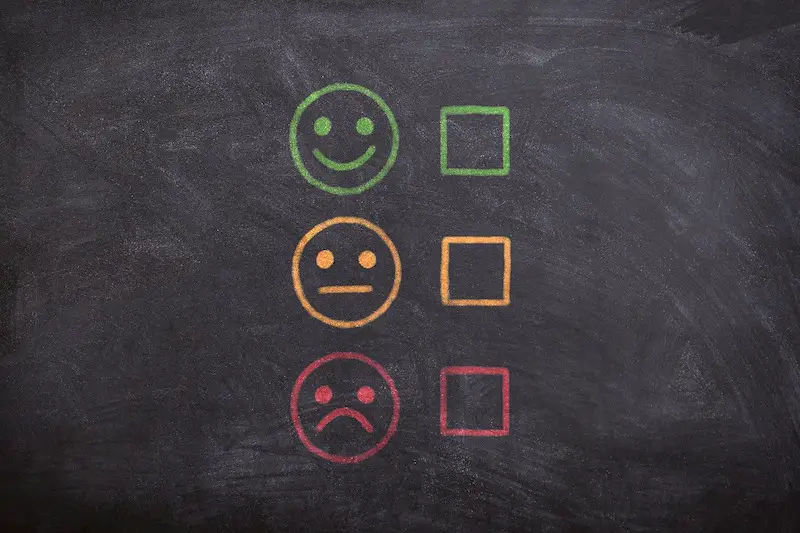 chalkboard with faces indicating smile, neutral and frowny expressions about Topamax for migraine reviews