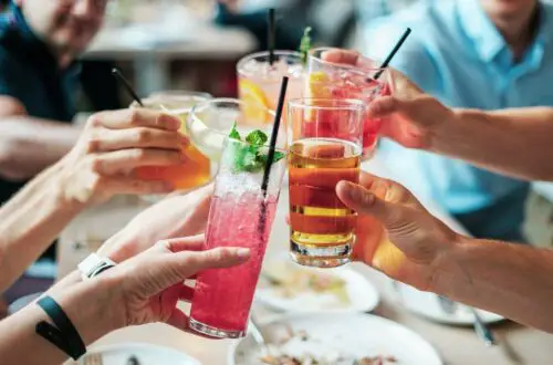 several hands holding drinks with the best and worst alcohols for migraine