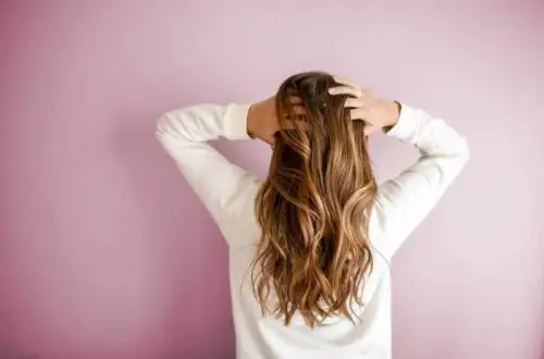 Woman touch her hair to show possible migraine allodynia